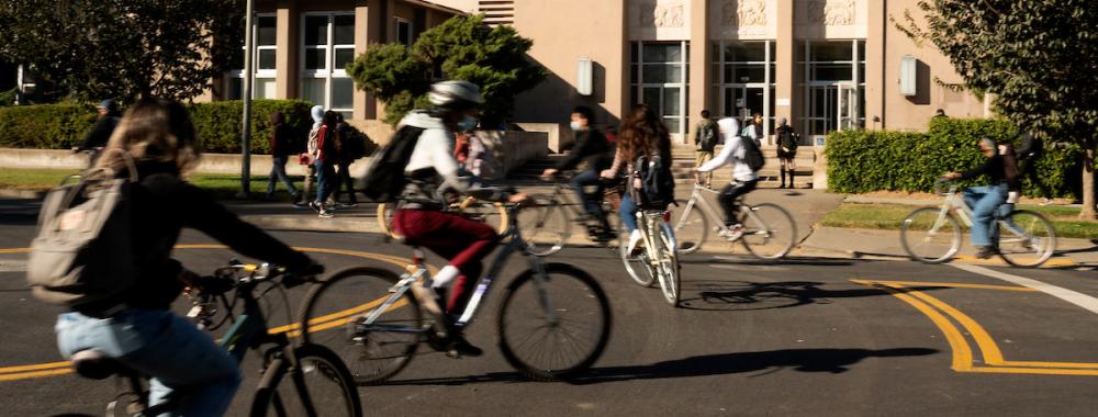 Students bike in front of Haring Hall.